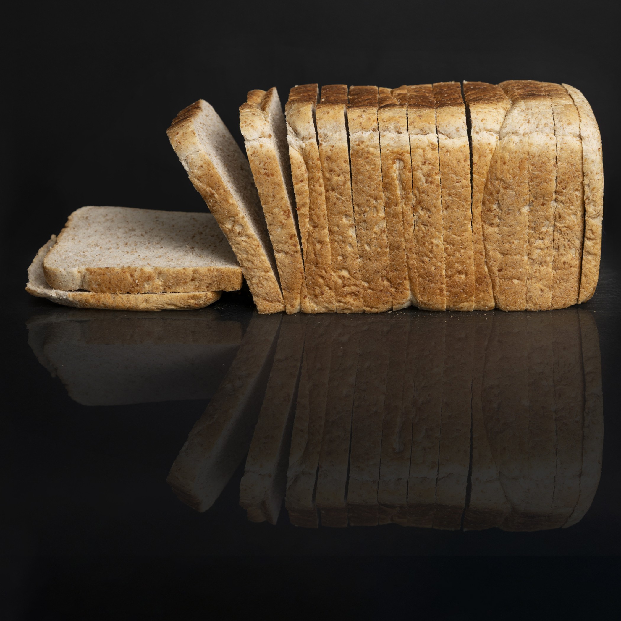 Sliced wholemeal loaf product photography on black backdrop, McDermott Bun Supplies