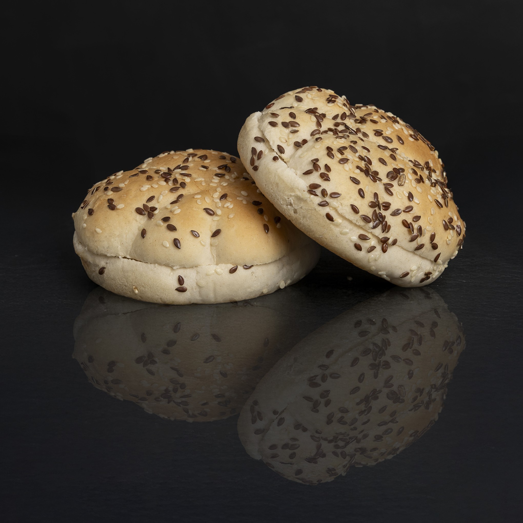 Seeded burger buns product photography on black backdrop, McDermott Bun Supplies